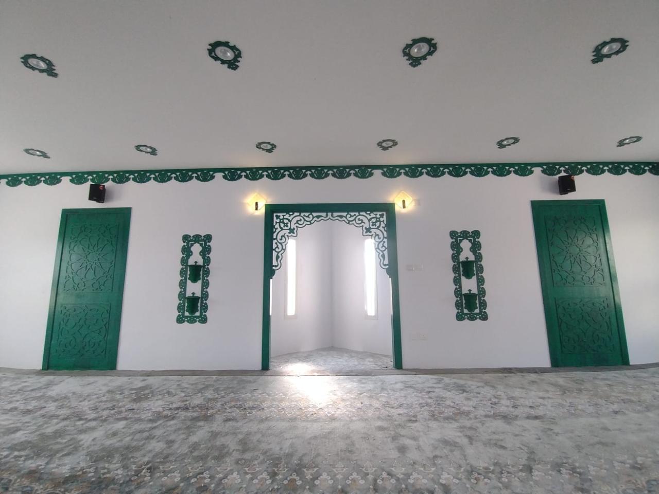 Al-Rubayyi bint Muawwidh Mosque (may Allah be pleased with her) — Prayer hall, carpet and green opening frames