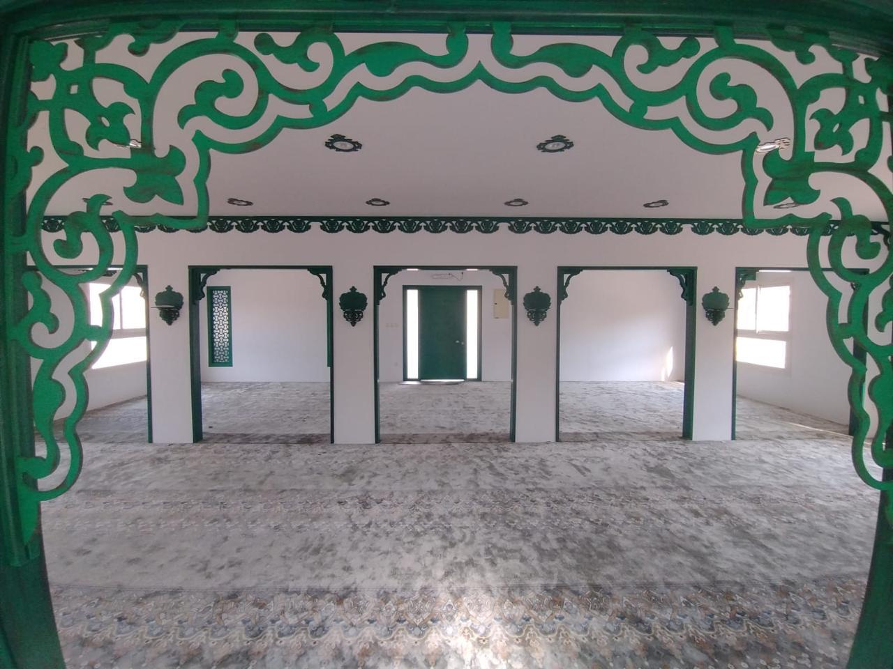 Al-Rubayyi bint Muawwidh Mosque (may Allah be pleased with her) — Repeated green opening frames and doors in the prayer hall