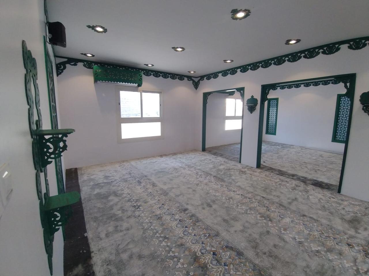 Al-Rubayyi bint Muawwidh Mosque (may Allah be pleased with her) — Prayer hall corner with green frames and ornamentation